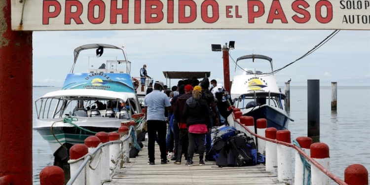 Migrantes de diversas partes del mundo suben a embarcaciones con destino a Capurganá, el 3 de mayo de 2021, en el embarcadero de Necoclí (Colombia).