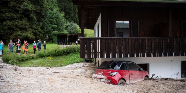 Un auto aparece semienterrado por las inundaciones en Schoenau am Koenigssee, Alemania.