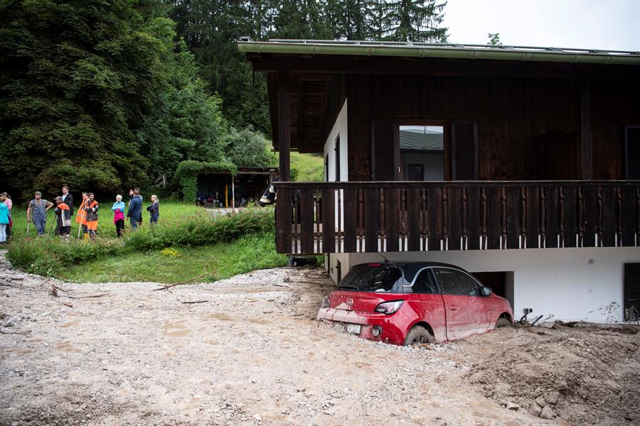 Un auto aparece semienterrado por las inundaciones en Schoenau am Koenigssee, Alemania.