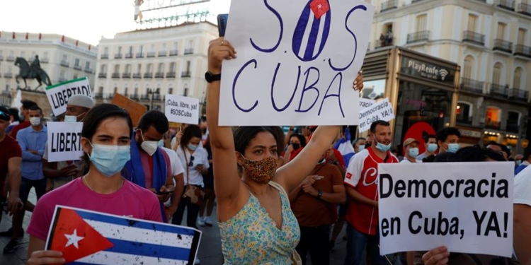 Varias personas participan en la concentración "Por una Cuba libre" frente a la embajada de Cuba en Madrid.