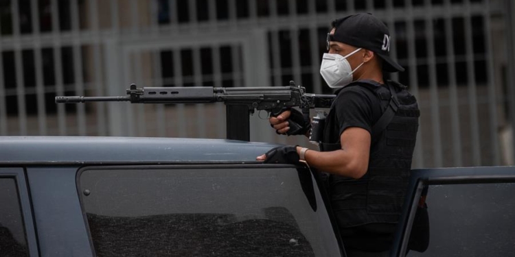 Un policía de las Fuerzas de Acciones Especiales (FAES) de la Policía Nacional Bolivariana viaja en una patrulla para entrar al barrio Cota 90, en Caracas (Venezuela), donde desde el miércoles pasado se desataron fuertes tiroteos.