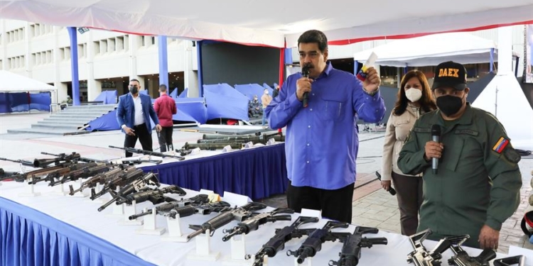 Fotografía cedida por el Palacio de Miraflores donde se observa al presidente de Venezuela Nicolás Maduro (c) mostrando parte del armamento incautado durante los operativos contra las bandas delictivas durante una alocución en Caracas (Venezuela).