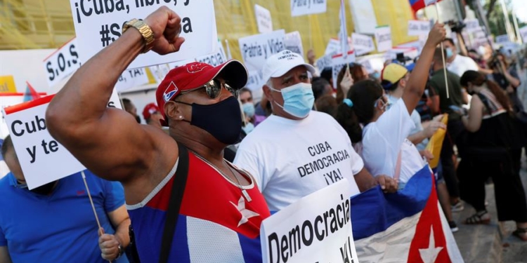 Varias personas participan en la concentración "Por una Cuba libre" frente a la embajada de Cuba en Madrid.