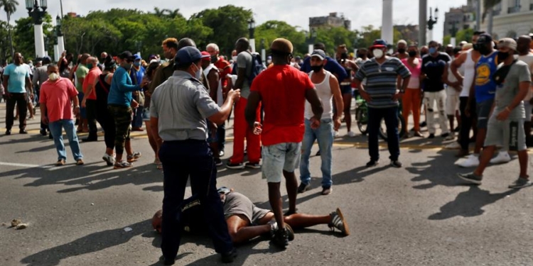 Un hombre permanece en suelo antes de ser arrestado en La Habana (Cuba). Cientos de cubanos salieron este domingo a las calles de La Habana al grito de "libertad" en manifestaciones pacíficas, que fueron interceptadas por las fuerzas de seguridad y brigadas de partidarios del Gobierno, produciéndose enfrentamientos violentos y arrestos.