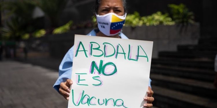 Una persona con una pancarta participa en una protesta contra la vacuna cubana Abdala hoy, frente a la sede del Programa de las Naciones Unidas para el Desarrollo (PNUD), en Caracas (Venezuela). El Colegio de Enfermeros de Caracas y varios docentes reclamaron este viernes que no se aplique a menores de edad en Venezuela la vacuna cubana Abdala, que consideran que es todavía un "prototipo" pese a haber recibido su autorización para el uso de emergencia por las autoridades de la isla.