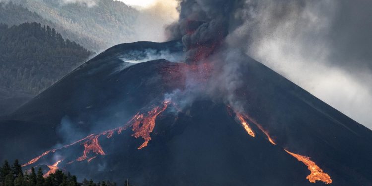 Momento en el que una nueva boca se ha abierto en la parte inferior del cono secundario del volcán de La Palma, de la que sale abundante lava / Ángel Medina / EFE.