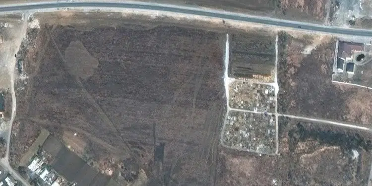 Una imagen satelital proporcionada por Maxar Technologies afirma mostrar una fosa común adyacente a un cementerio de pueblo existente en el extremo noroeste de Manhush, a unos 20 kilómetros al oeste de Mariupol, Ucrania, el 19 de marzo de 2022 (publicado el 21 de abril de 2022). Maxar revisó imágenes satelitales desde mediados de marzo hasta mediados de abril e indica que la expansión del nuevo conjunto de tumbas comenzó entre el 23 y el 26 de marzo de 2022 y continuó expandiéndose. Las tumbas están alineadas en cuatro secciones de filas lineales (que miden aproximadamente 85 metros por sección) y contienen más de 200 tumbas nuevas, afirma Maxar. (Rusia, Ucrania) EFE