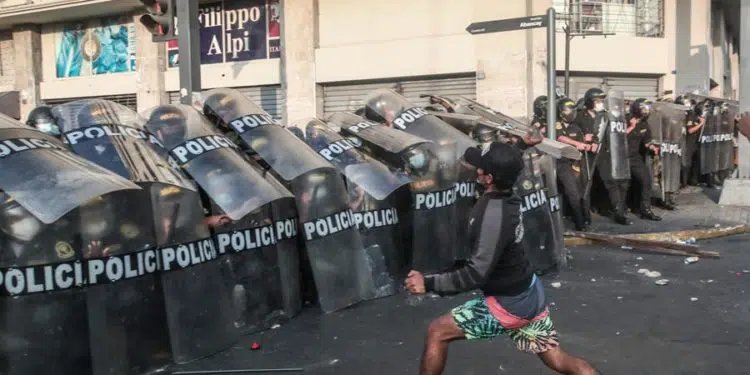 Opositores del presidente peruano, Pedro Castillo, chocan con policías durante una manifestación para pedir la renuncia del mandatario hoy, en Lima (Perú). Miles de peruanos desafiaron este martes el toque de queda ordenado por el presidente Pedro Castillo para Lima y su vecina provincia de Callao y se manifestaron en la capital para pedir la renuncia del mandatario. EFE/ Aldair Mejía