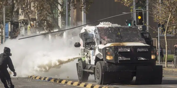 Manifestantes chocan hoy con Carabineros durante una marcha con motivo del Día Internacional del Trabajo, en Santiago (Chile). La marcha acabó con enfrentamientos entre los manifestantes y un grupo de vendedores ambulantes que disparó contra ellos, dejando hasta el momento una mujer herida de bala. EFE/Diego Reyes Vielma