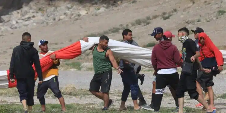 Migrantes participan durante una manifestación hoy a orillas del Río Bravo en Ciudad Juárez, Chihuahua (México). Agentes de Patrulla Fronteriza de El Paso, Texas, dispararon hoy lunes balas de goma contra migrantes venezolanos para disolver una manifestación en la Frontera de Ciudad Juárez. EFE/Luis Torres