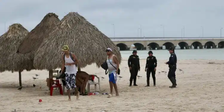 Policías retiran a personas de la playa, ante la posible llegada del huracán Milton, este lunes en el puerto de Progreso, Yucatán (México). Autoridades mexicanas alertaron este lunes de que Milton, que se intensificó por la mañana a huracán categoría 5, podría impactar durante la noche entre los municipios de Celestún y Progreso, en el estado de Yucatán, en el sureste del país, por lo que pidieron a la población extremar precauciones. EFE/Lorenzo Hernández