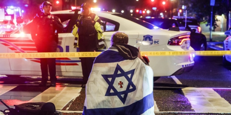 FOTODELDÍA WASHINGTON (Estados Unidos), 22/05/2025.- Un hombre con una bandera israelí cerca del lugar donde dos personas fueron asesinadas a tiros cerca del Museo Judío Capital en Washington, D.C., EE. UU., este jueves. Según una publicación en redes sociales de la secretaria de Seguridad Nacional de EE. UU., Kristi L. Noem, las dos personas fallecidas eran empleados de la embajada de Israel. EFE/ Will Oliver